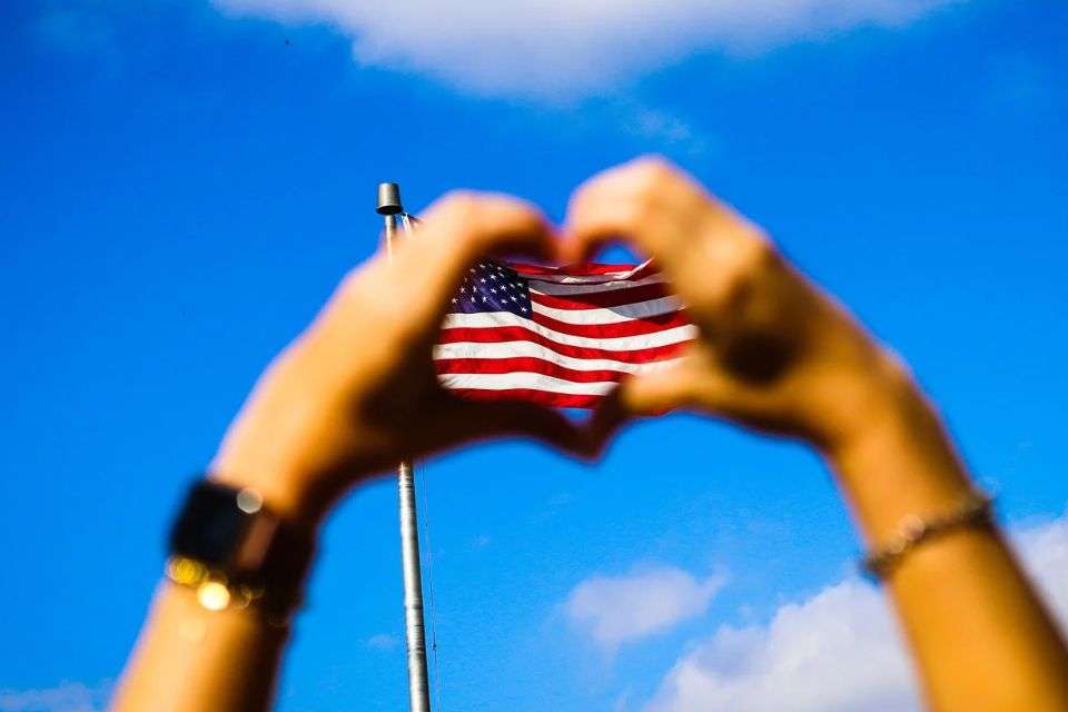 Human Hands Making a Heart Gesture on the American Flag - How to Get My Filipina Girlfriend to the US - Blossoms Dating Blog