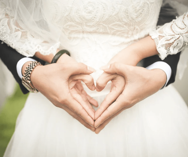 Filipina with Her Foreigner Husband Making the Heart Gesture During Their Wedding